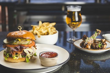 Burger, Fries and wings served with a glass of craft beer at Cardinal Restaurant