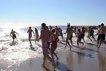 Polar Bear Plunge people running into Atlantic ocean from an Atlantic City beach on New Year's Day.