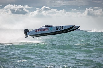 Offshore Power Boat Racing as Coco's Monkey hits a wave and jumps out of the water during racing on open ocean.