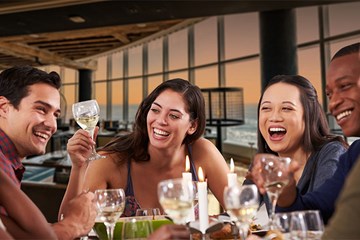 Group of diners enjoying drinks over a meal at an Atlantic City restaurant.