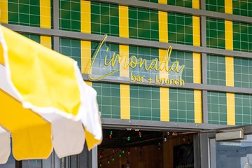 Limonada bar + brunch sign with yellow and white umbrella