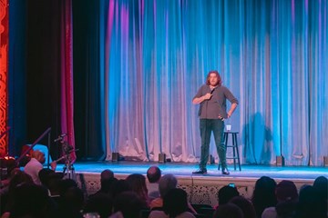 Comedian on stage at an AC Jokes Comedy Club performance.