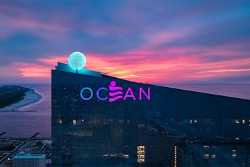 Ocean Casino Resort top of building with sunrise and inlet in background.