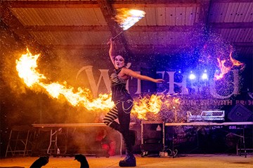 Performer using pyrotechnics on stage at Witch Craft NJ.