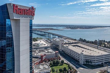 Harrah's Hotel Tower stands tall against the backdrop of the Absecon Inlet during the daytime.