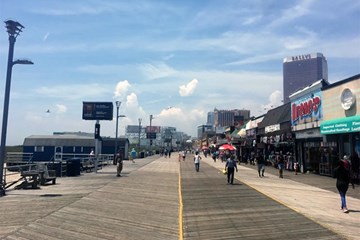 Atlantic City Boardwalk with store fronts and people walking.