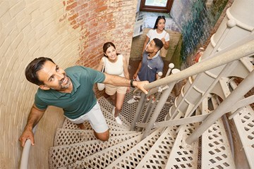 Group of young adults climbing stairs of Absecon Lighthouse in Atlantic City.
