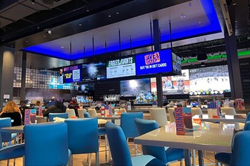 Dave and Buster's Atlantic City bar and table seating with large screen tv with sports.